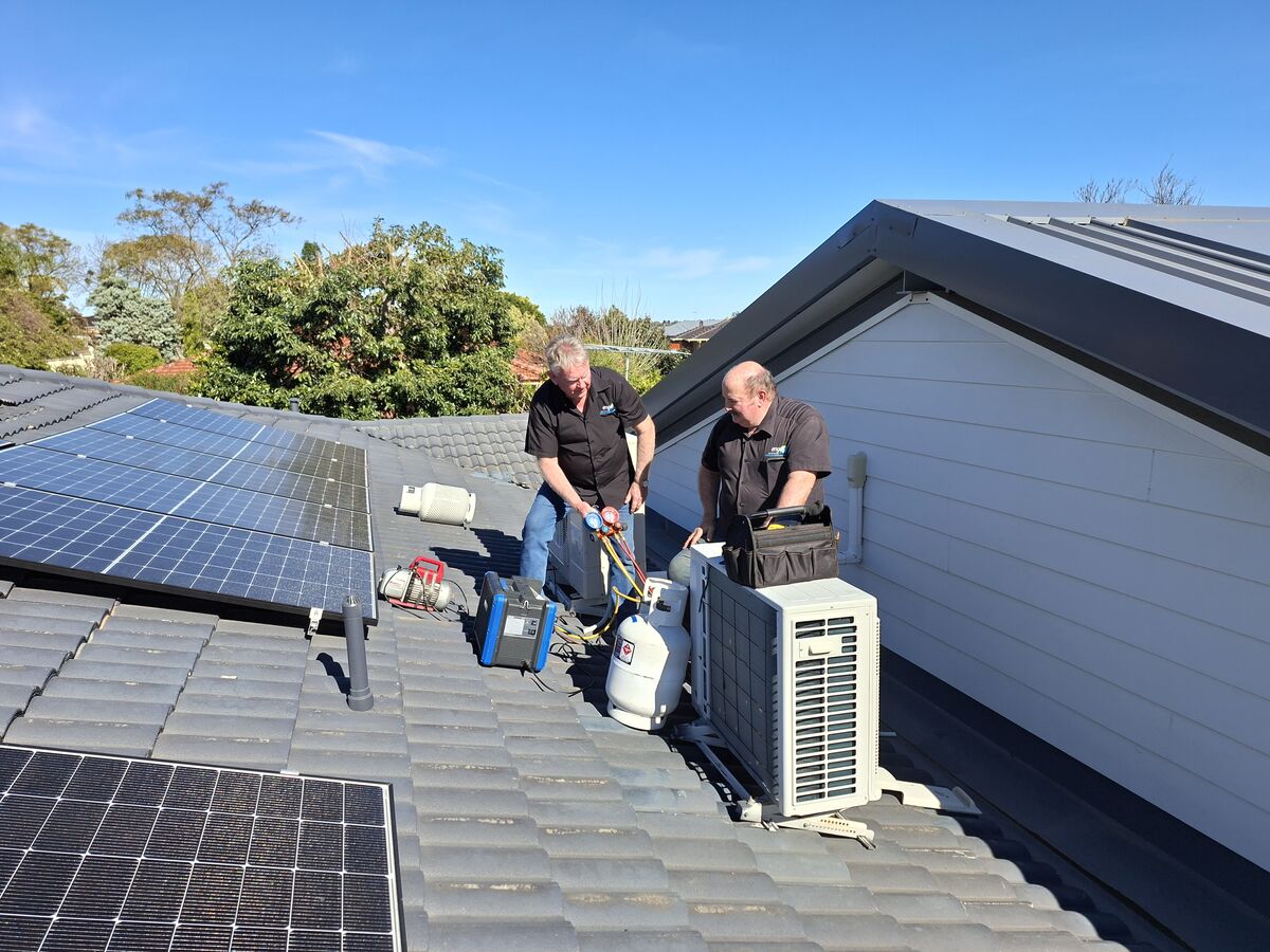 Engas technicians carrying out a Retro-fit on a split-system Air-conditioner unit on a Perth rooftop